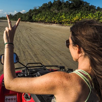 Young,Woman,From,The,Back,Driving,Quad,On,The,Beach